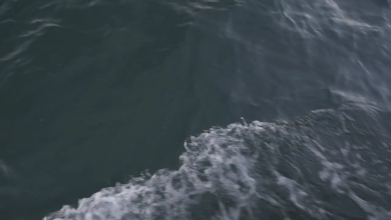 waves from a boat moving in the ocean camera onboard handheld camera tilt up