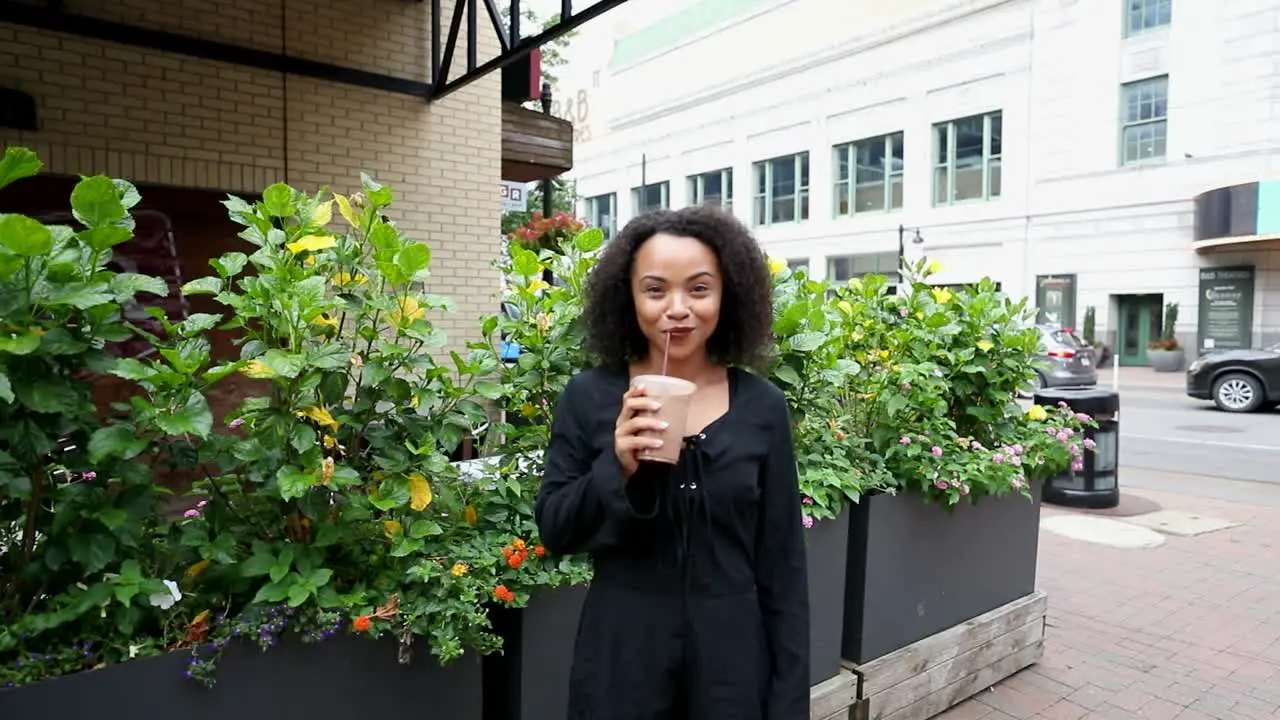 Young woman bumps coffee into the camera