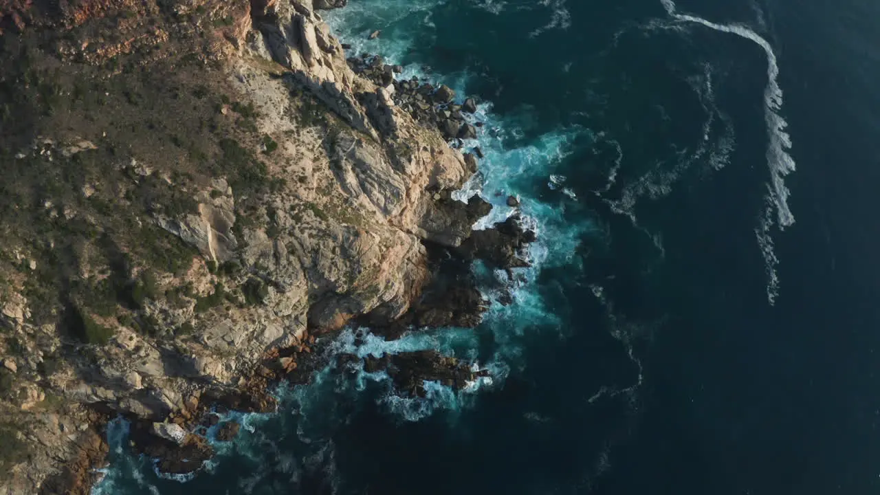 Aerial Orbit of Big Waves Crashing against Rocks in Ocean