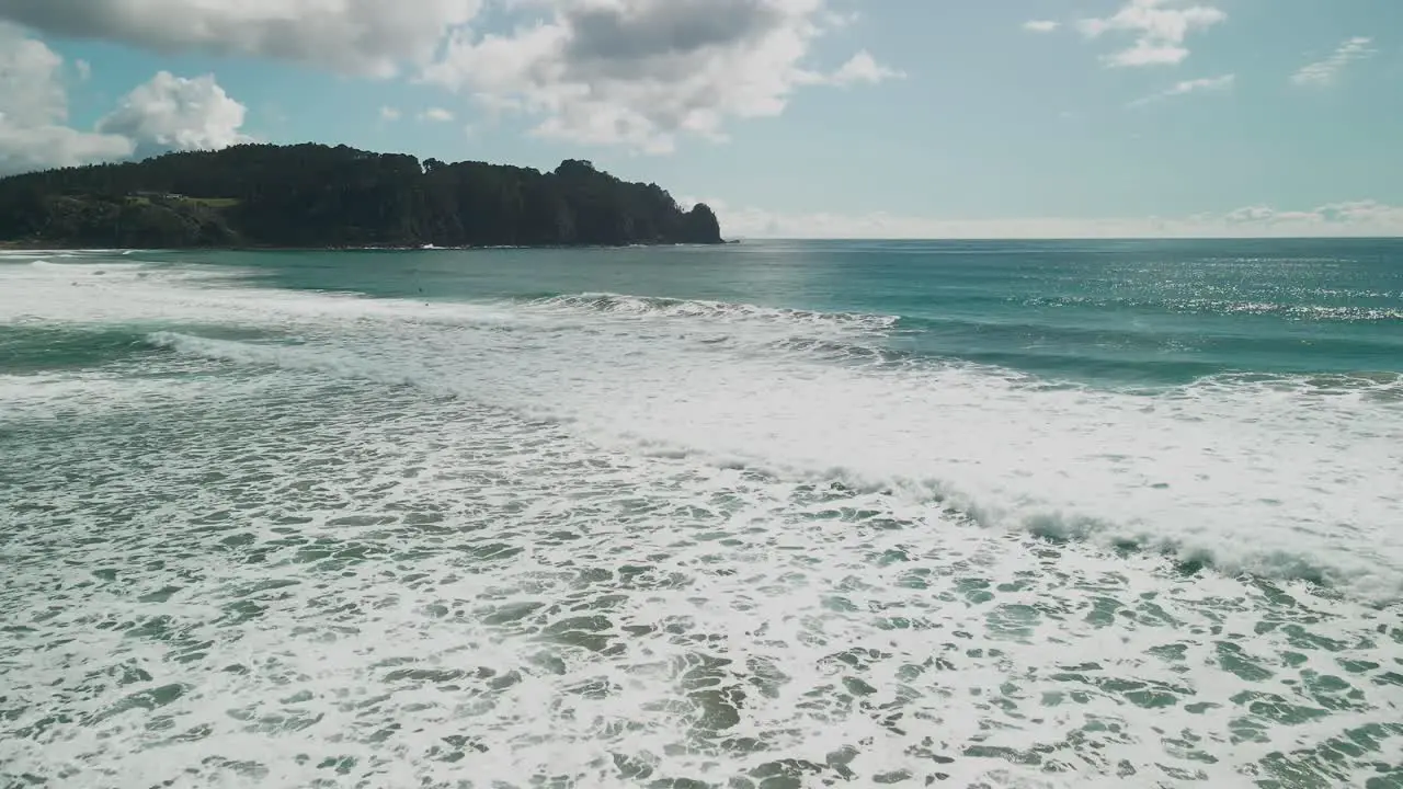 Drone flying over breaking waves on a sunny day