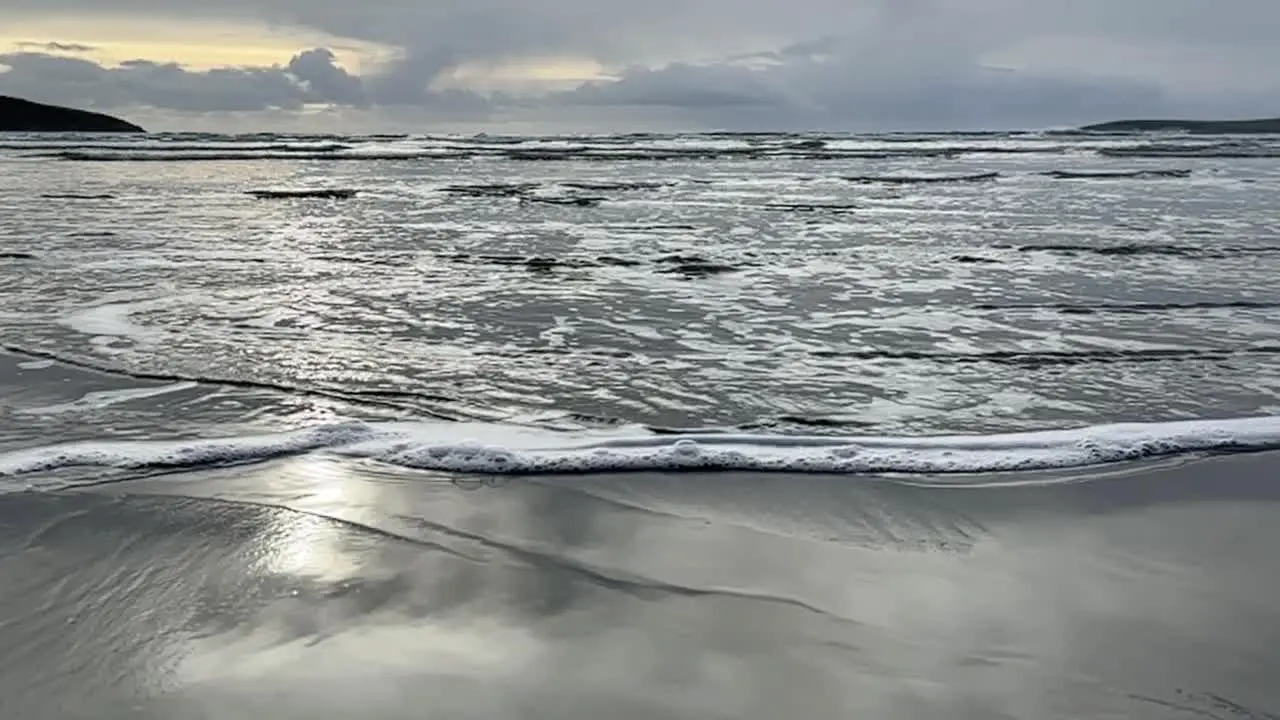 Slow motion movement waves on a sandy beach in wintertime in Ireland