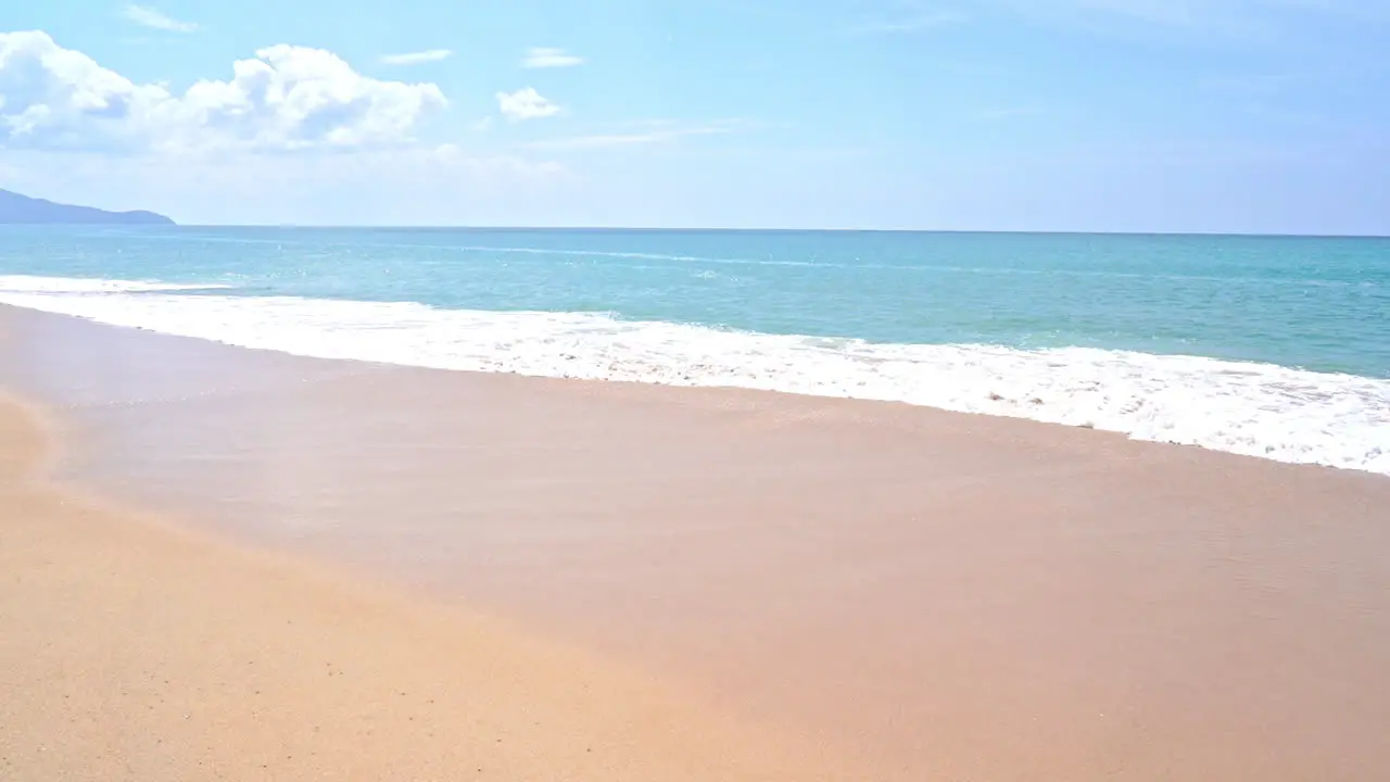 Slow-motion waves creep onto a sandy beach