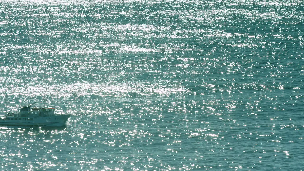 A ferry travels across a shimmering ocean