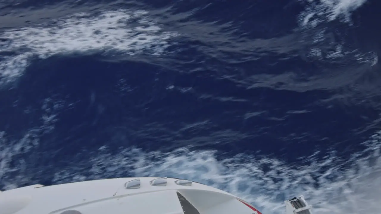 Cruise ship sailing in ocean close up on waves and a part of a ship