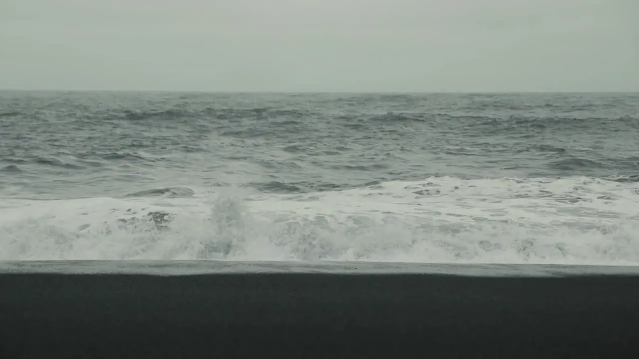 Waves crash on a black sand beach in Iceland