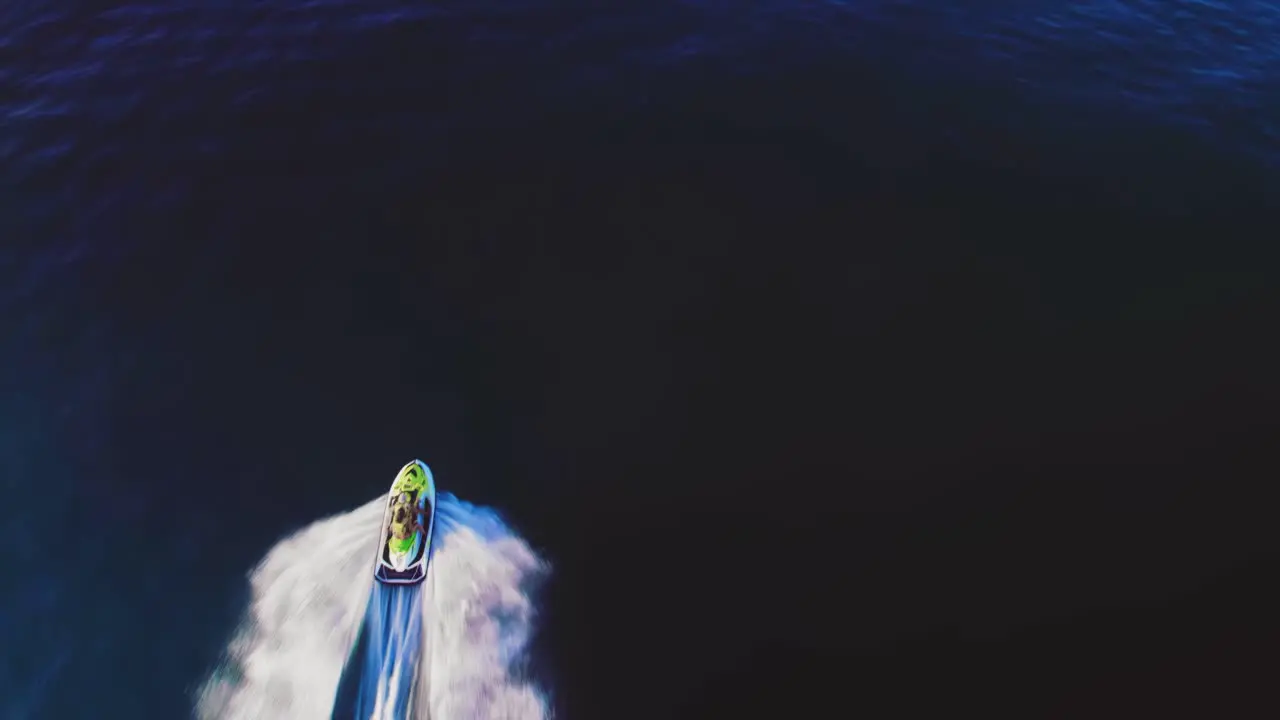 Jetski on the Mediterranean Sea birdseye view tilting up to reveal the coastline of the South of Spain