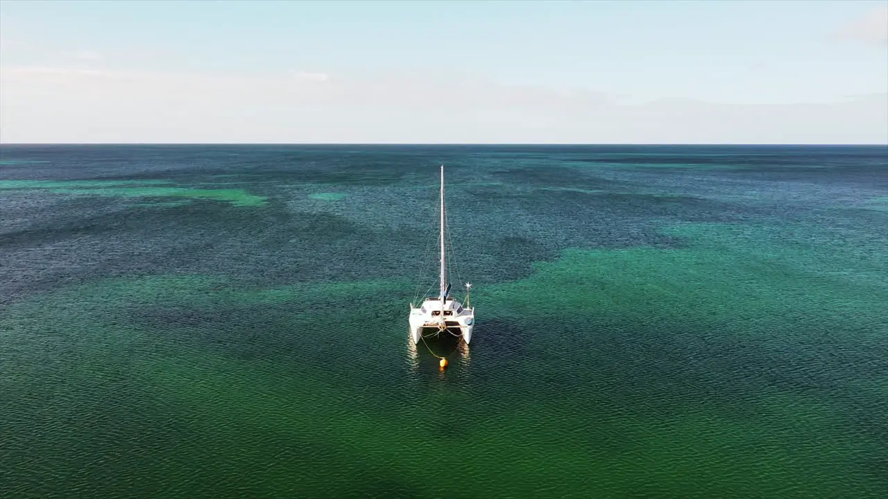 Aerial view of anchored sailboat in the crystal clear waters of the ocean