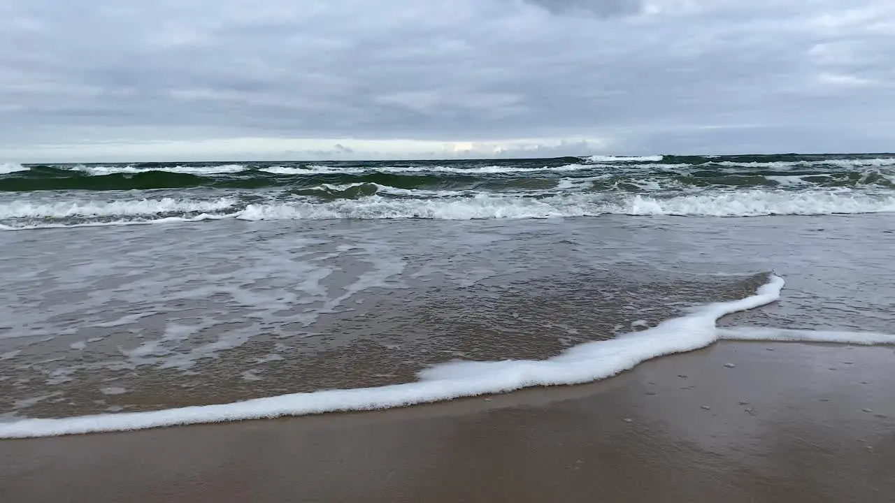 Waving sea by a sandy beach low angle Wladyslawowo poland