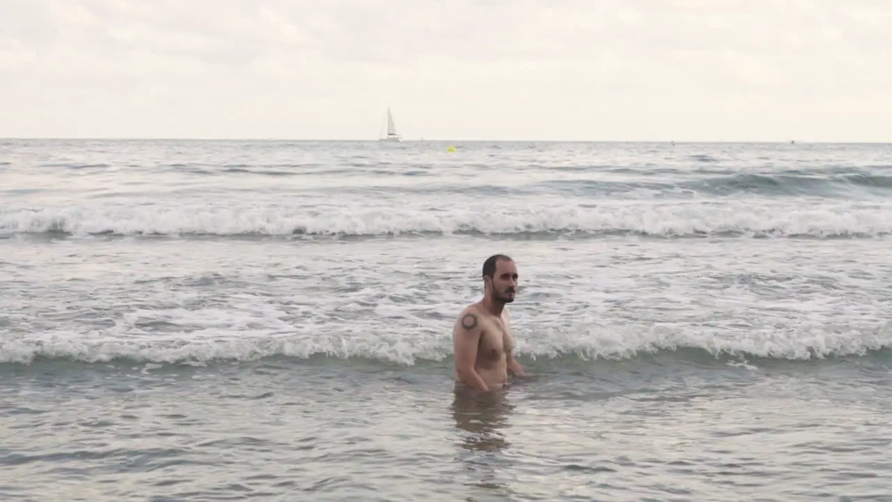 Handsome hispanic bathing off grid style at mediterranean sea Barcelona