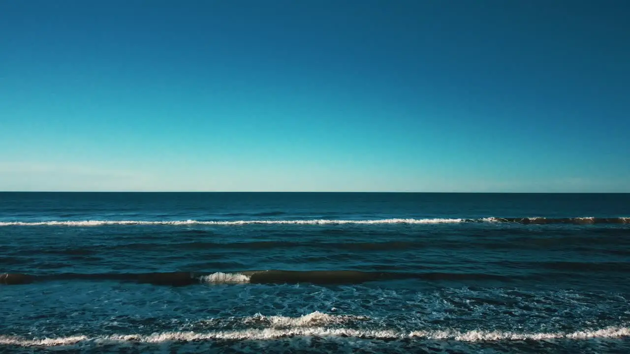 Rising shot of the sea waves on a sunny day aerial view