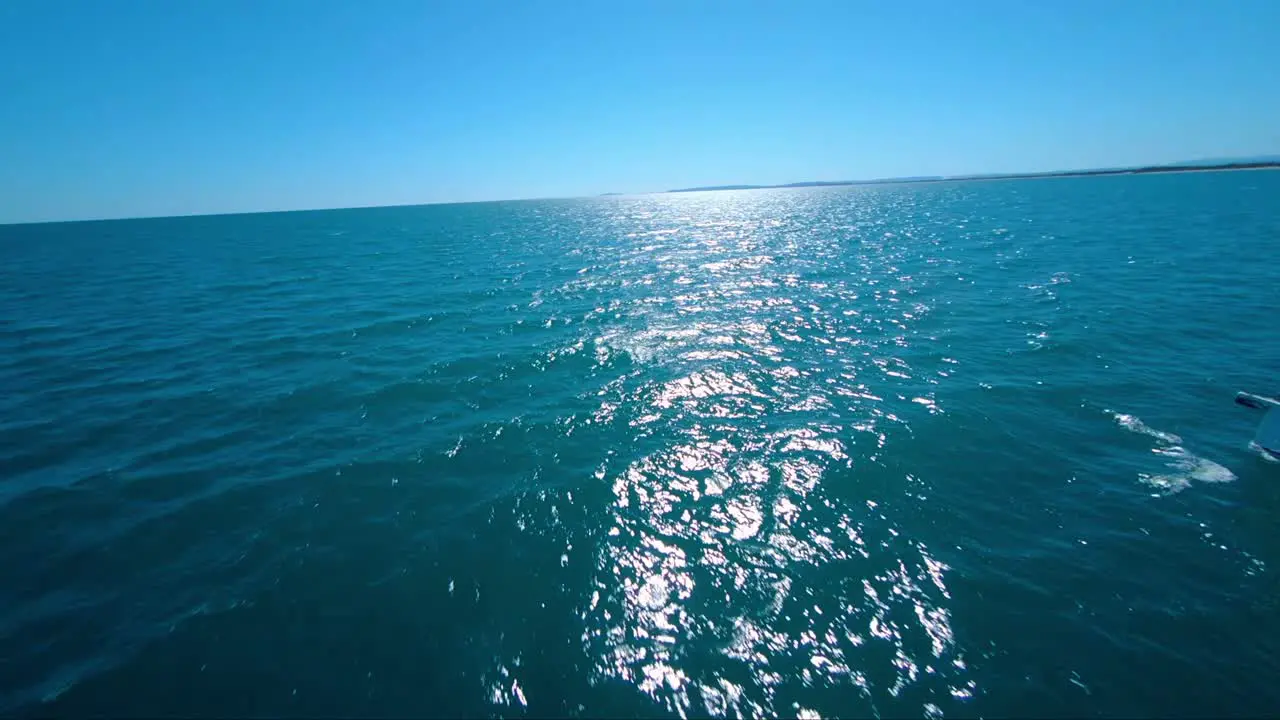 Acrobatic diving FPV shot of a sailboat sailing through the tropical ocean off the coast of France