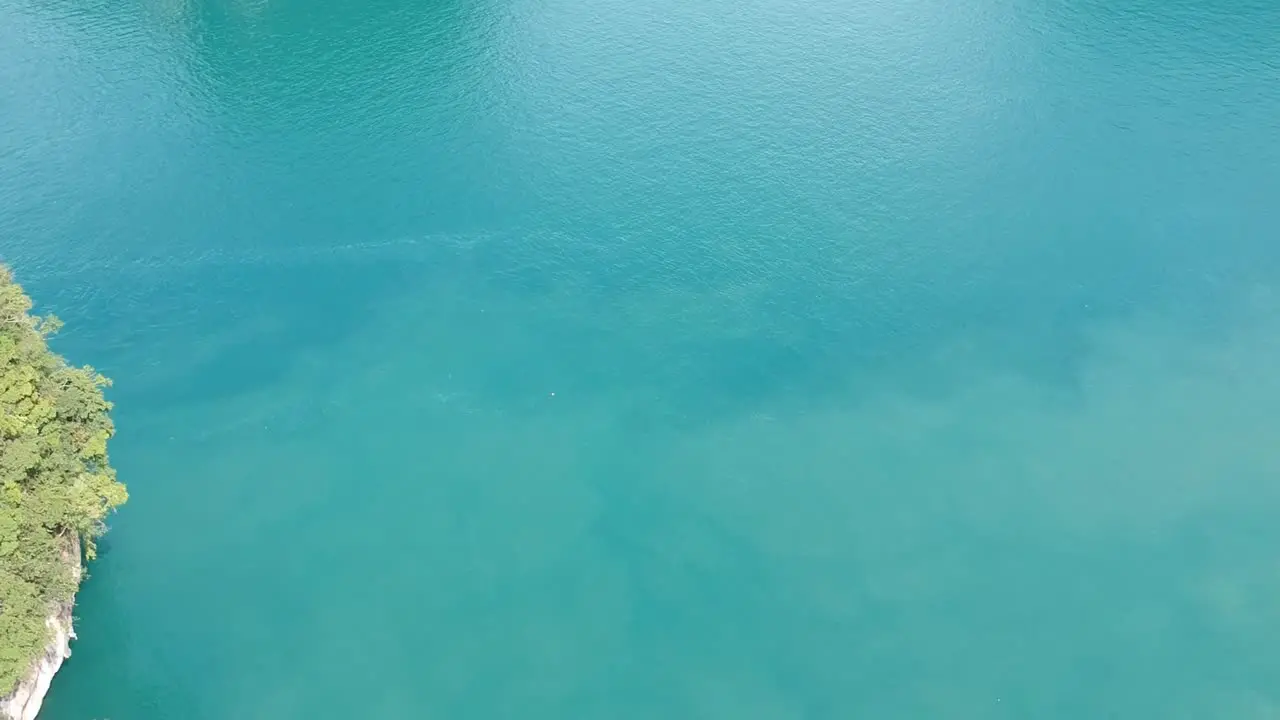 Drone footage of islands in Thailand with limestone rock formation sticking out of the water and the ocean in background-4