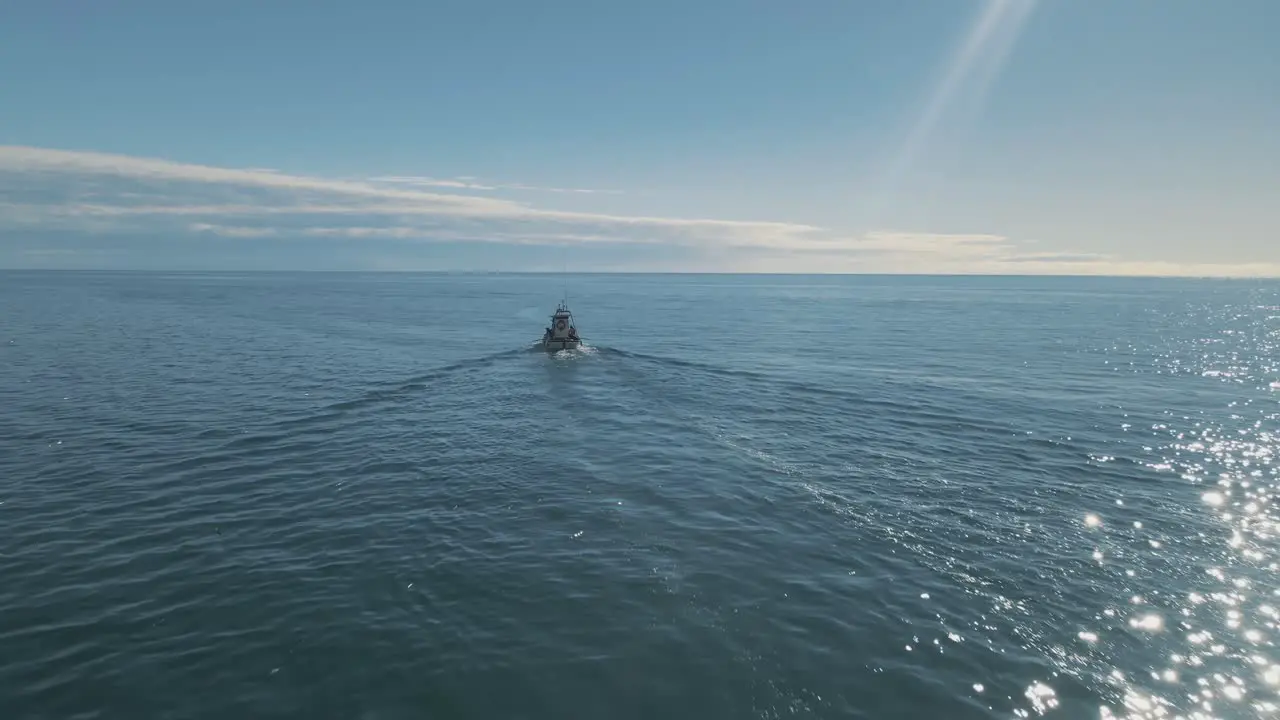 Aerial view of fishing boat motoring in the clear calm ocean