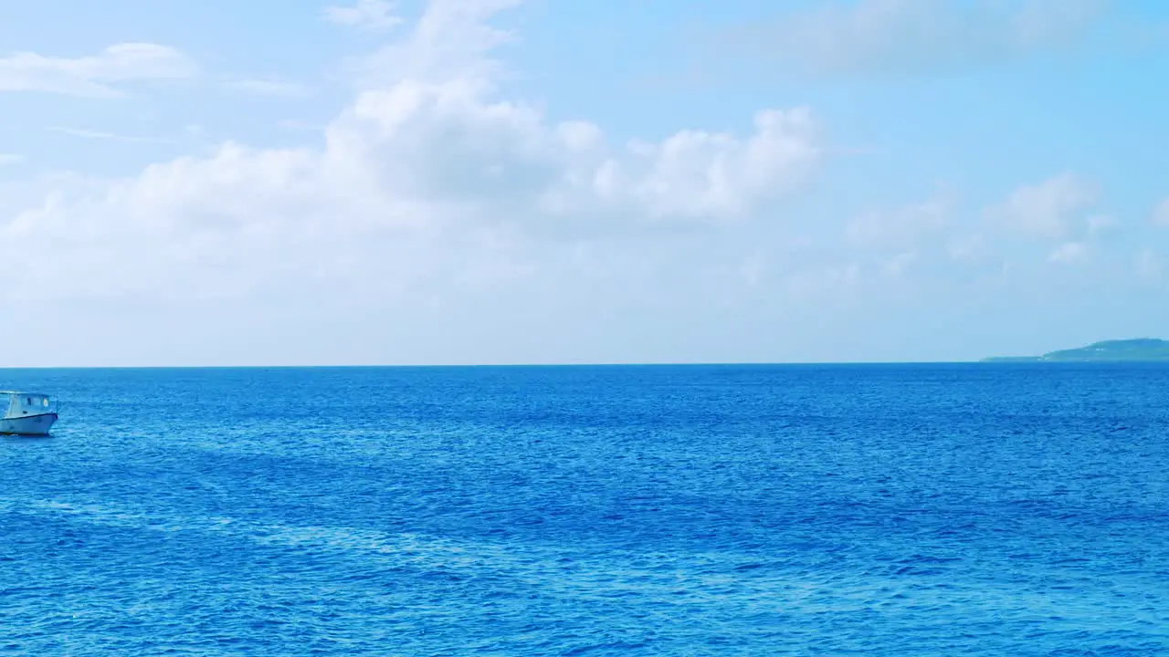 Small fishing boat entering frame as it comes into shore from sea on a beautiful sunny day in Curacao