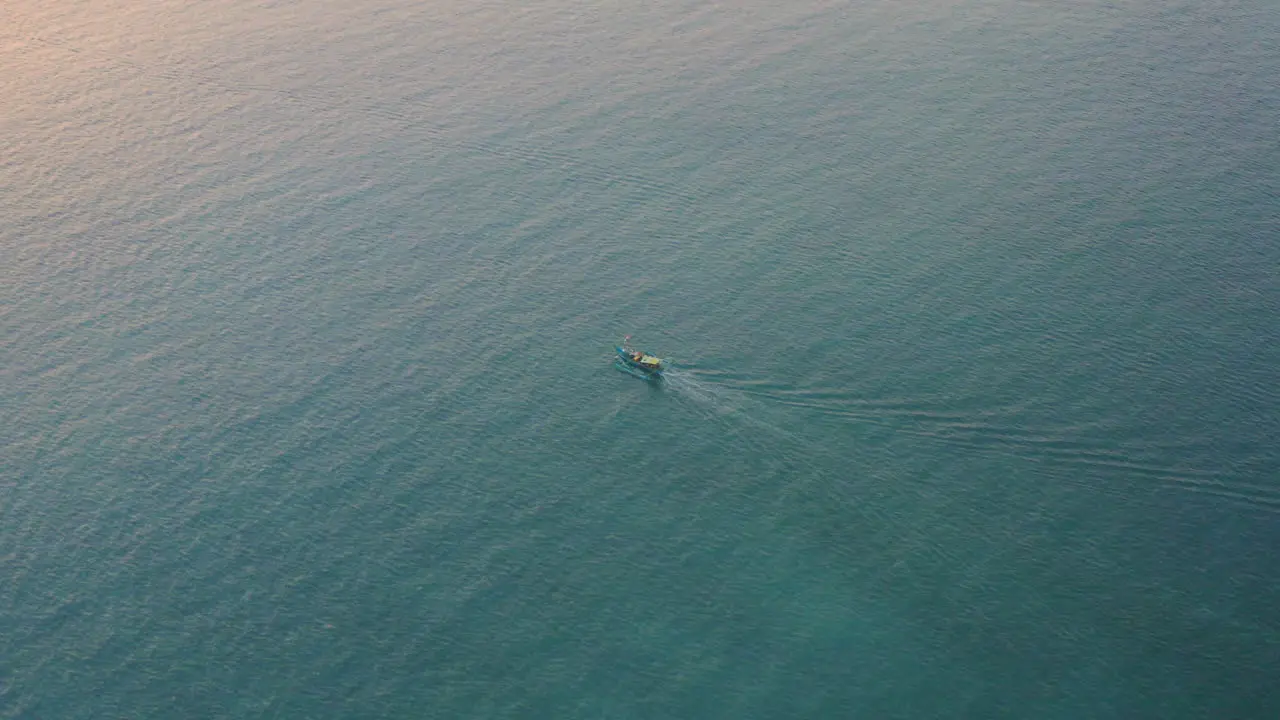 A small local tour boat surrounded by the vast tropical waters off the coast of Bali aerial