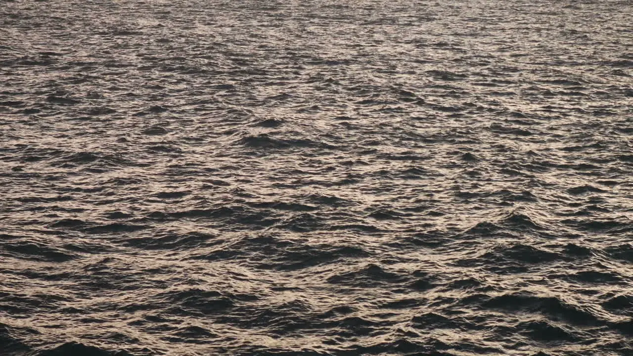 Wavy open sea with sun reflecting off it in late afternoon from mainland Malta to Gozo