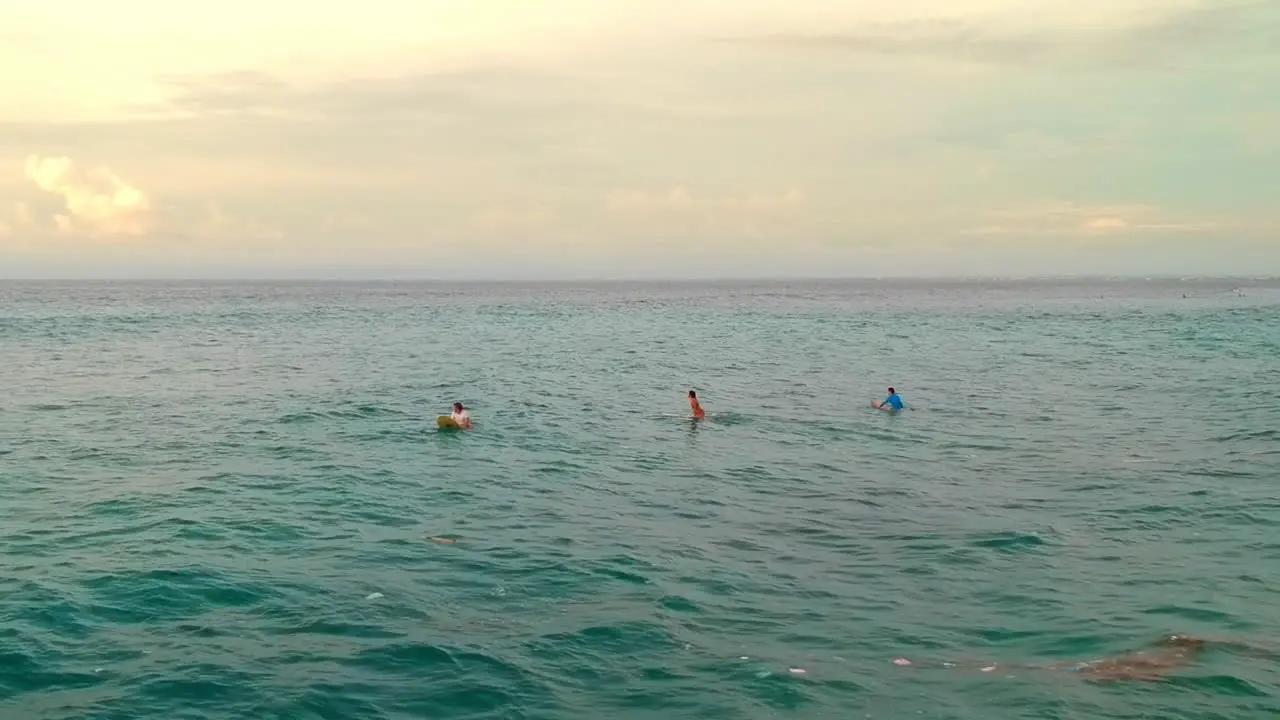 Surfers At The Beach In Bali Indonesia Waiting For Perfect Wave To Ride On A Sunset drone shot