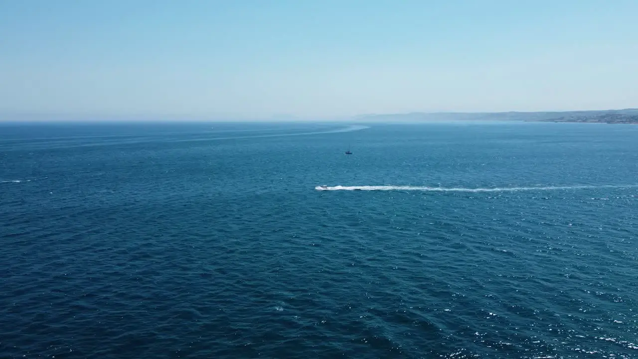 Lonely boat speeding through blue tropical sea water aerial view