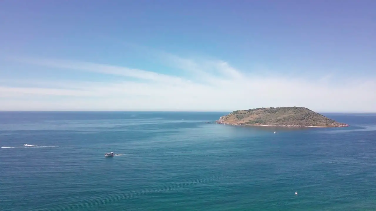 Wide aerial of ship sailing over beautiful ocean in summer