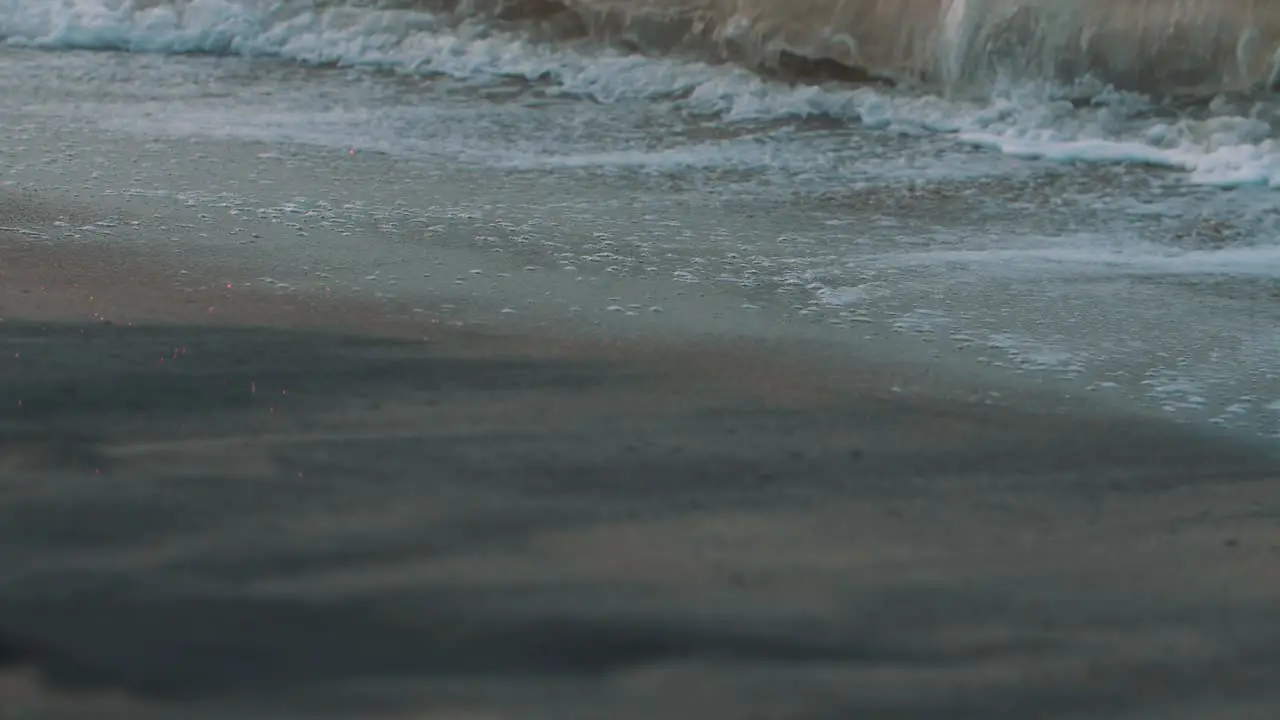 Foam of the waves crashing on the sand of the beach Beautiful close-up macro slow-motion shot