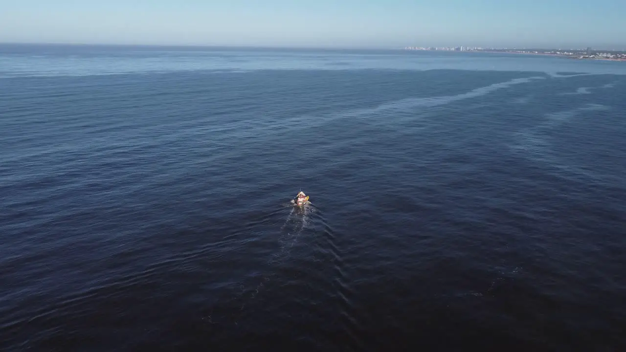 Aerial tracking shot of fishing boat on the uruguayan coast in the Atlantic Ocean