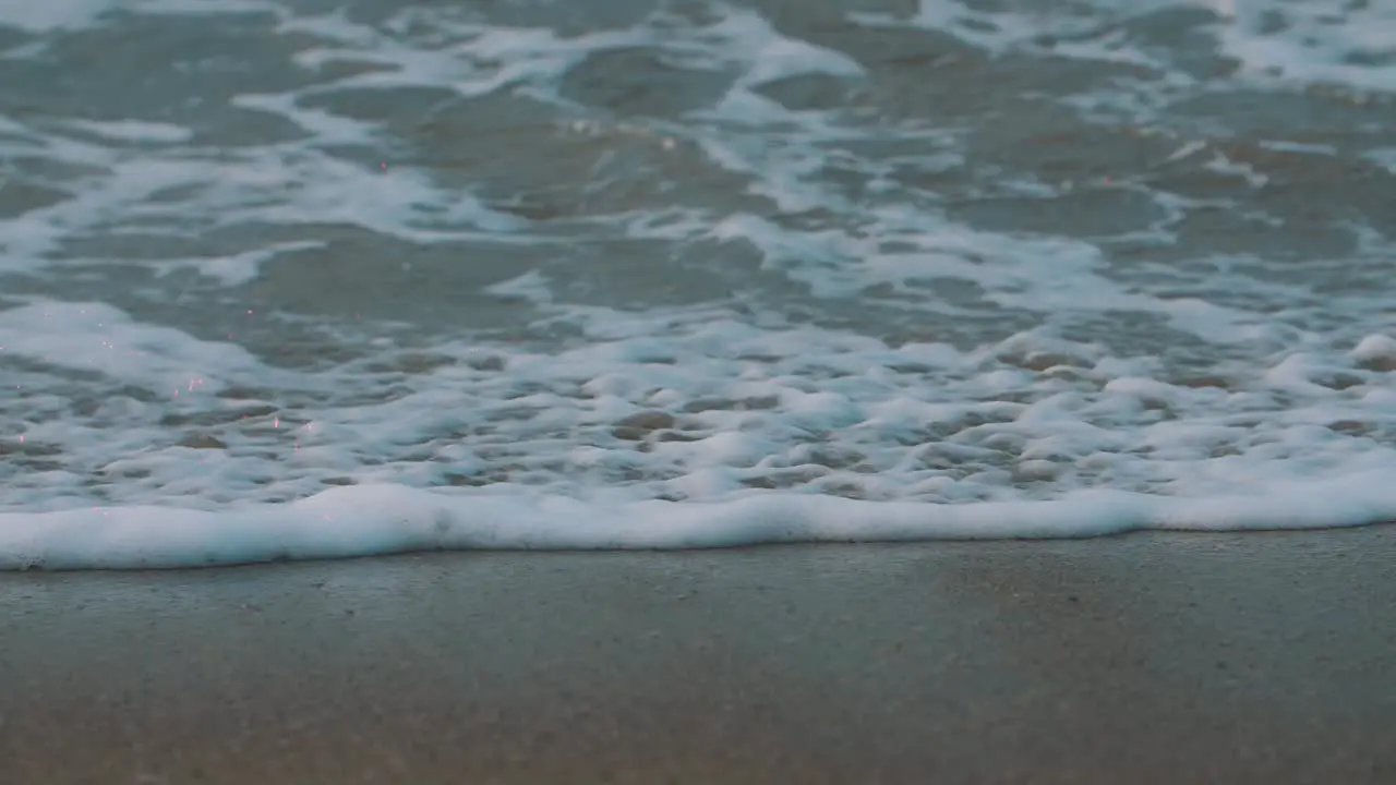 close-up shot of the foam of the waves crashing on the sand the shore of the beach in colombia