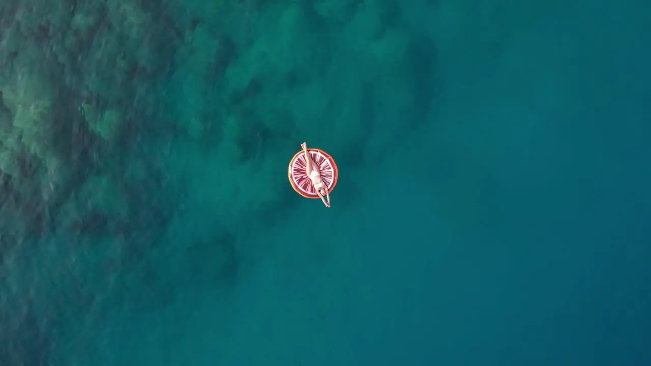 in summer the girl lies on the colorful seabed the drone shoots upwards at sea Turkey