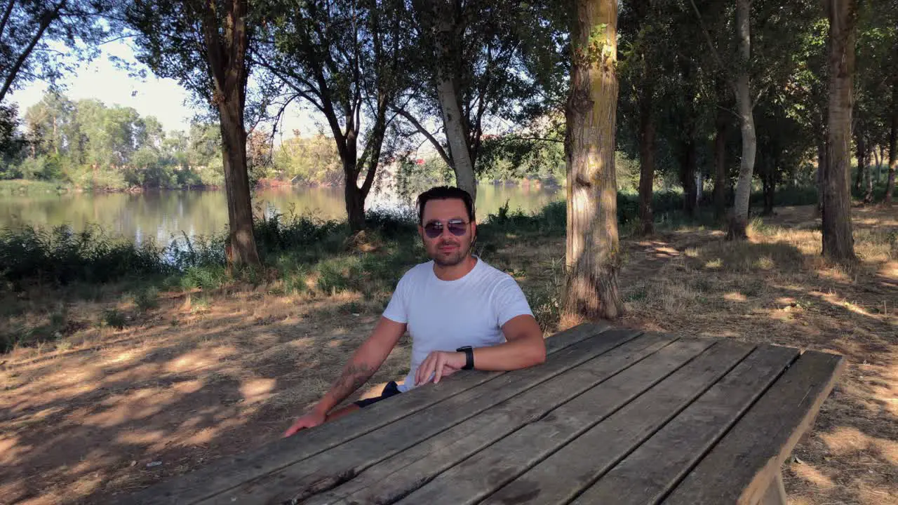 Man sitting at a wooden table in the forest