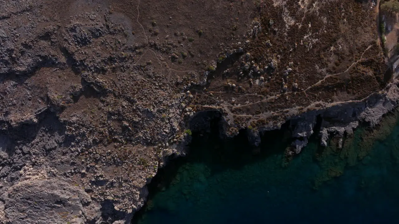 Descending aerial shot over rough Rhodes coastline