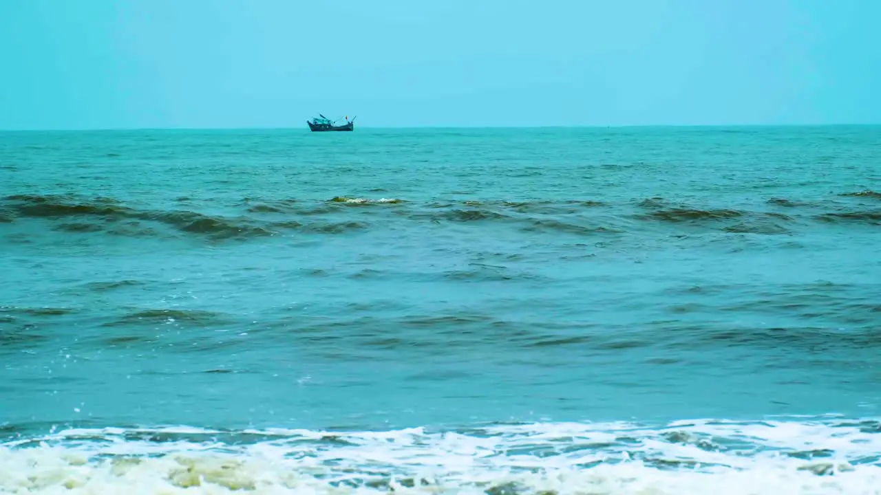 Waves in the sea with a fishing boat in the background at indian ocean