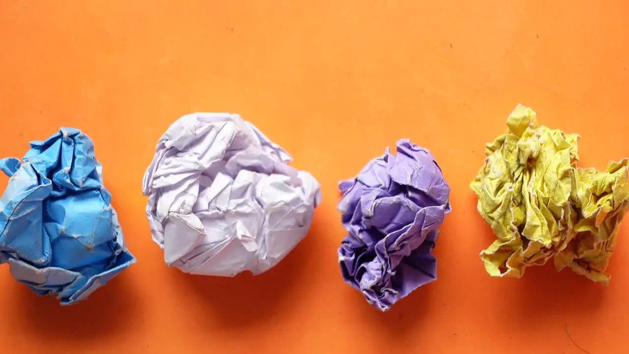 Top view of crumpled paper balls on orange background