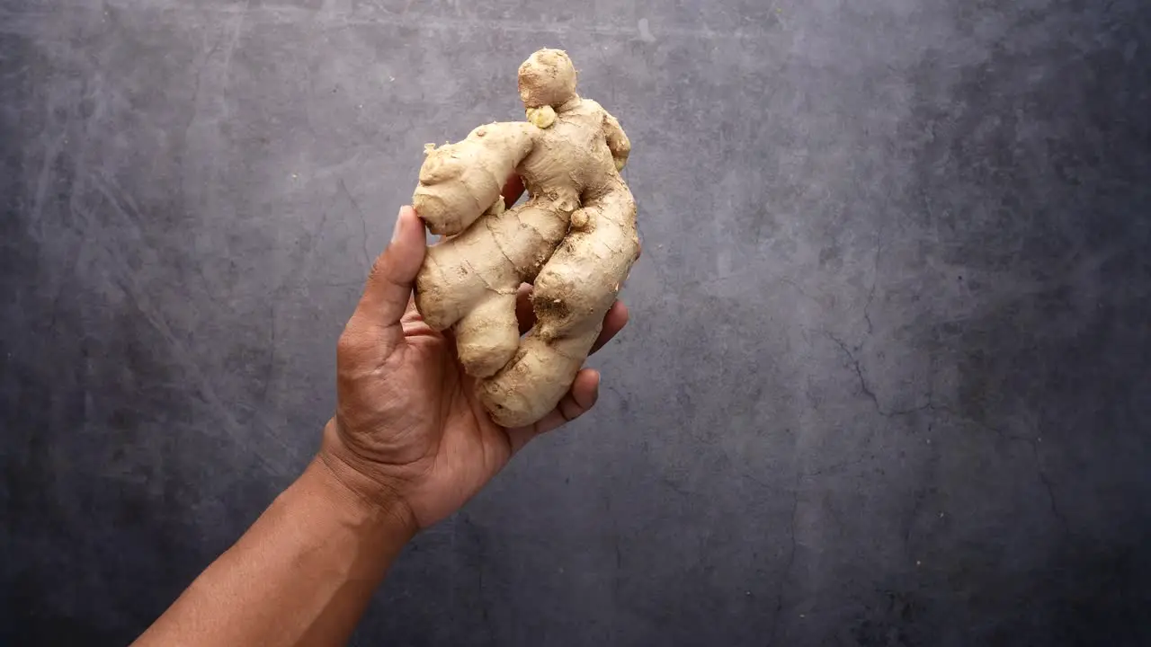 Top view of holding ginger on black background 