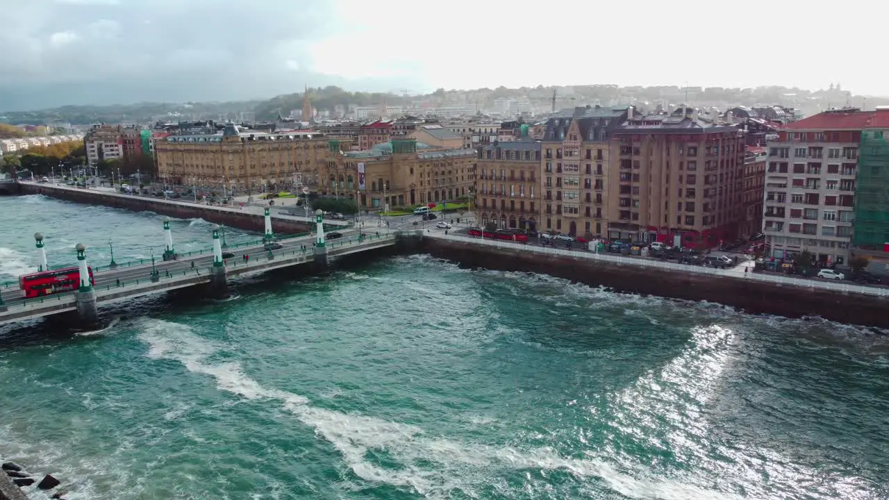 San Sebastian with rough waters on a windy day with double-decked bus over a bridge