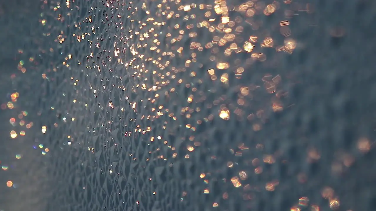 Close up of golden bokeh glowing on a rough surface during a summer sunrise