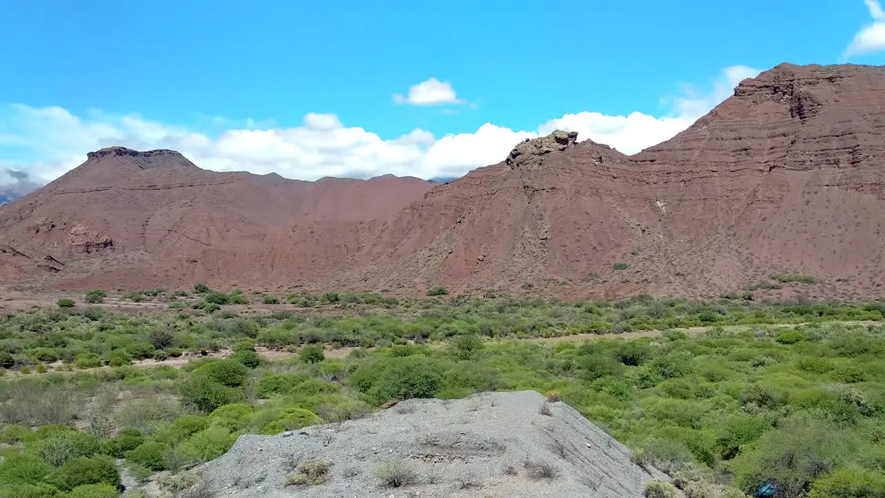 Panning shot of a spectacular sunny scenic green valley and rough mountain wilderness