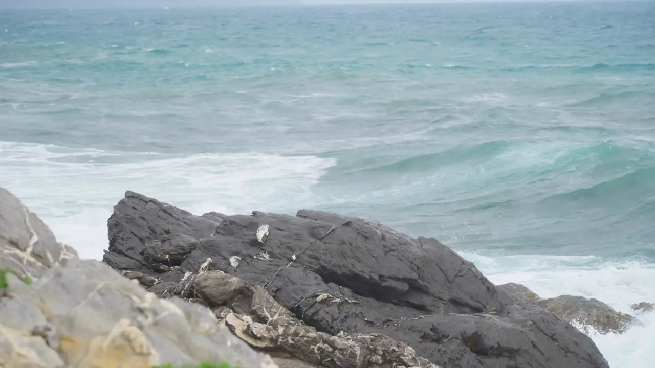 Slow motion static shot of crashing waves against rocks in the Mediterranean Sea