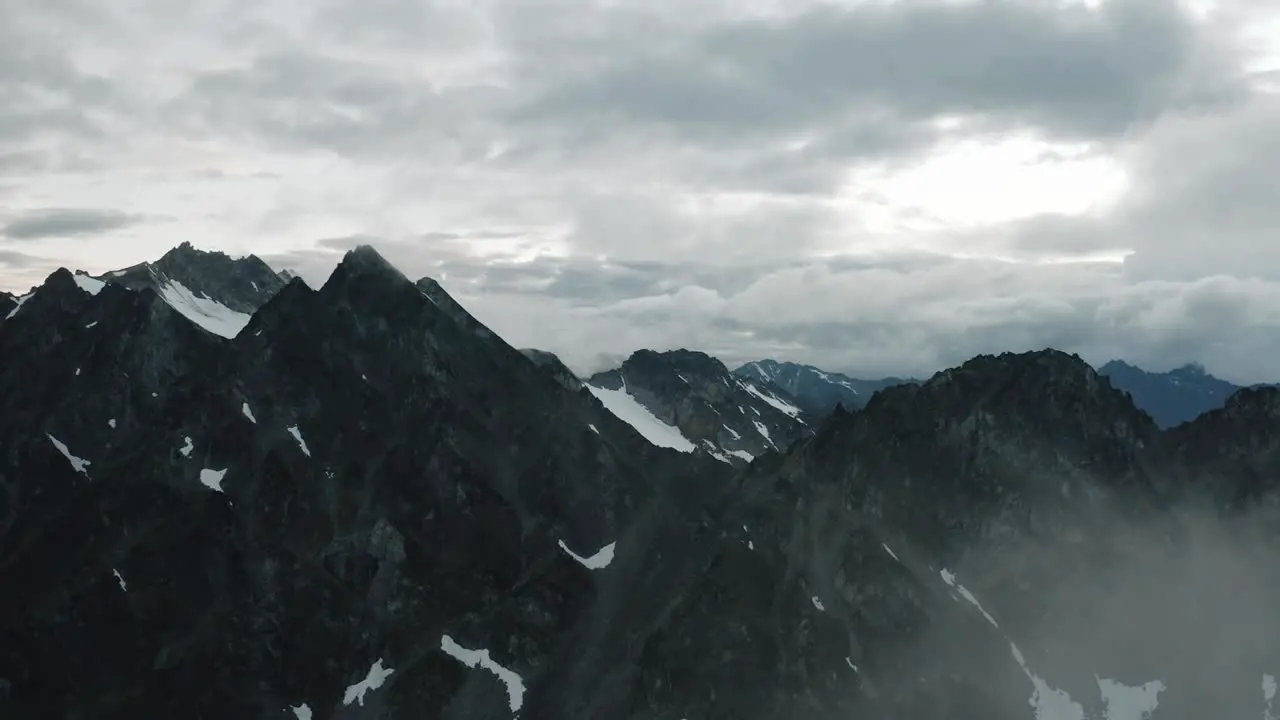 Alaskan Rugged Mountain Range Drone Flying through the Clouds and Mountains at Sunset