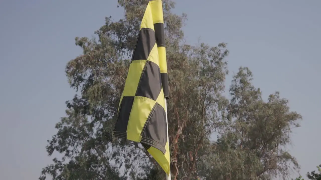 A black and yellow checker golf flag with subtle movement