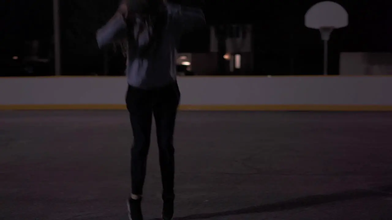 Slow motion jump shot at outdoor court at night teenage girl with brown hair