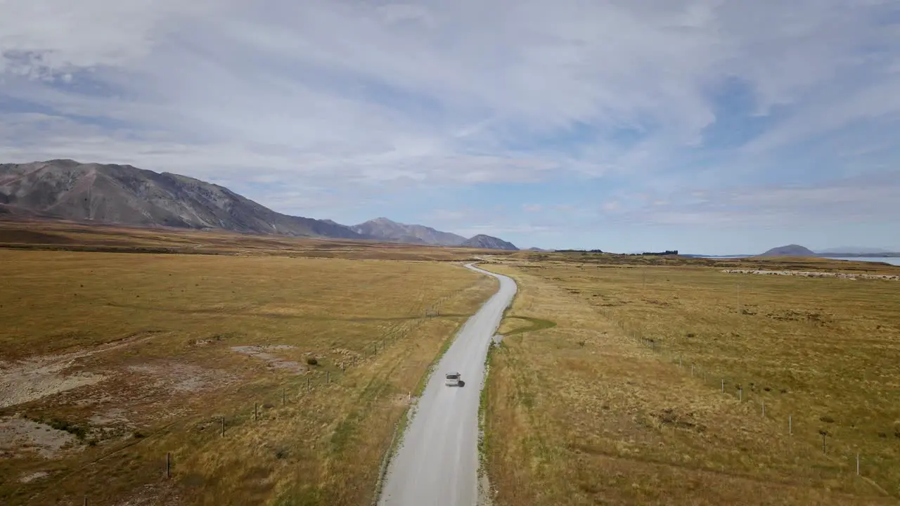 Off-road vehicle on remote unpaved road in sunny New Zealand