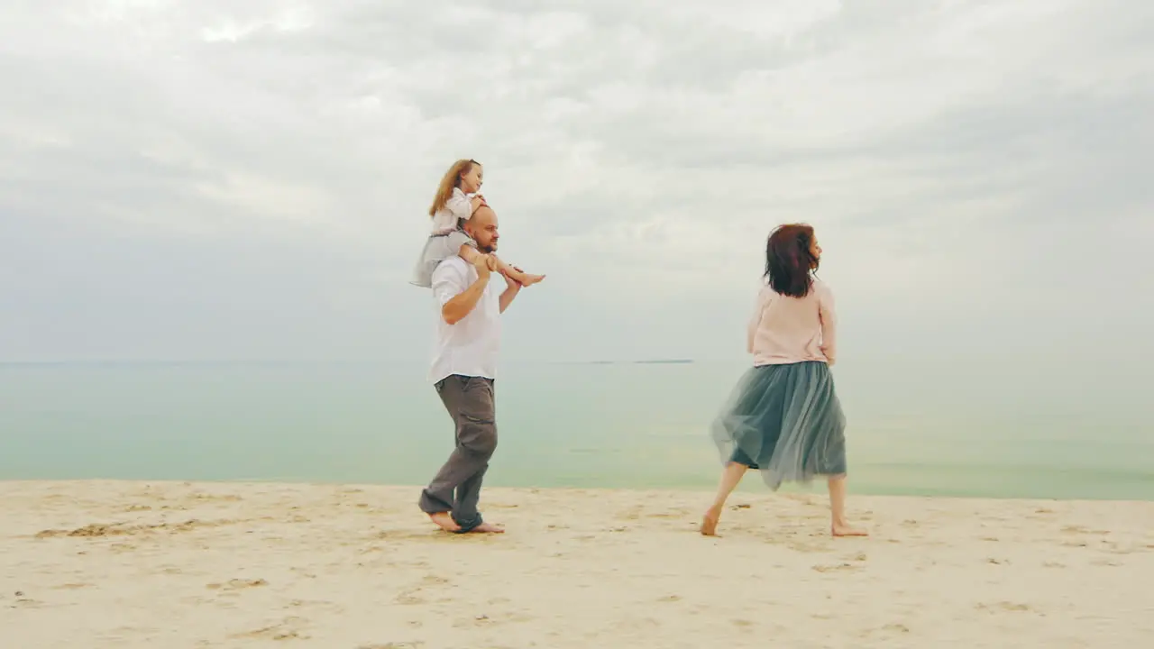 Happy Family Of Three People Running On The Beach 02