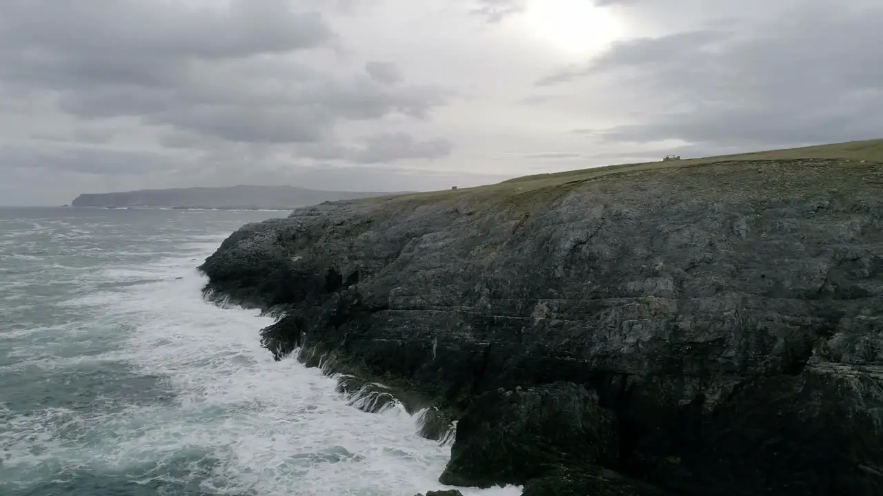 Epic cliffside aerial with rough seas thrashing the coastline