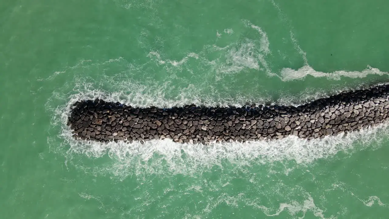 4K Drone view of Rough sea Ocean waves crashing against the bare stones Deep blue sea with crashing waves and foam on rocks