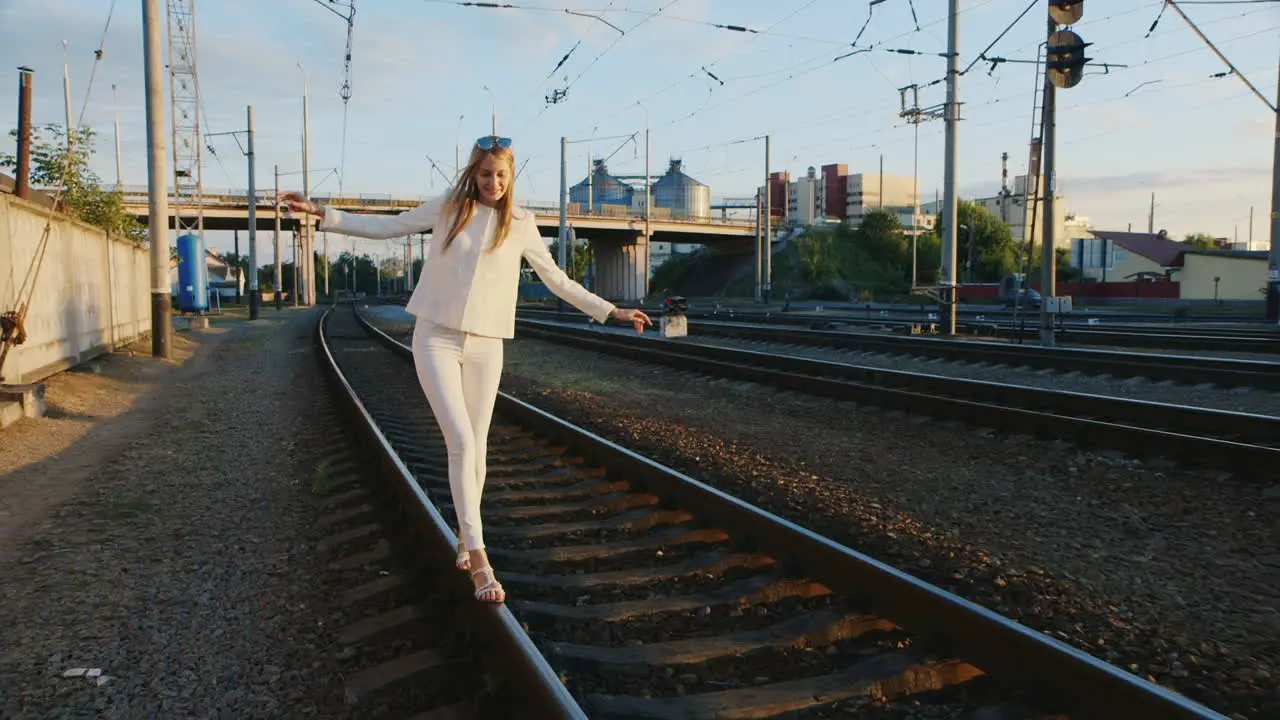 Young Woman Having Fun Walks By Rail To Rail Laughing Steadicam Shot