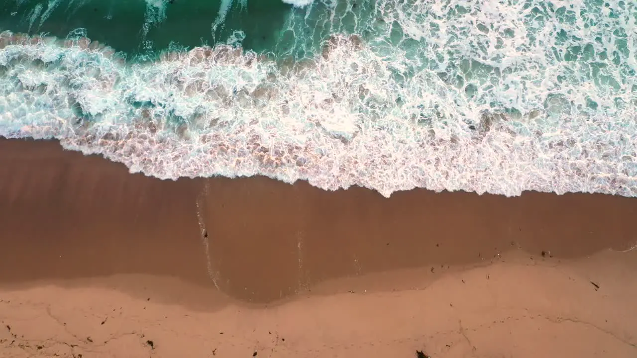 Aerial View Of Ocean Waves Rolling At The Empty Beach