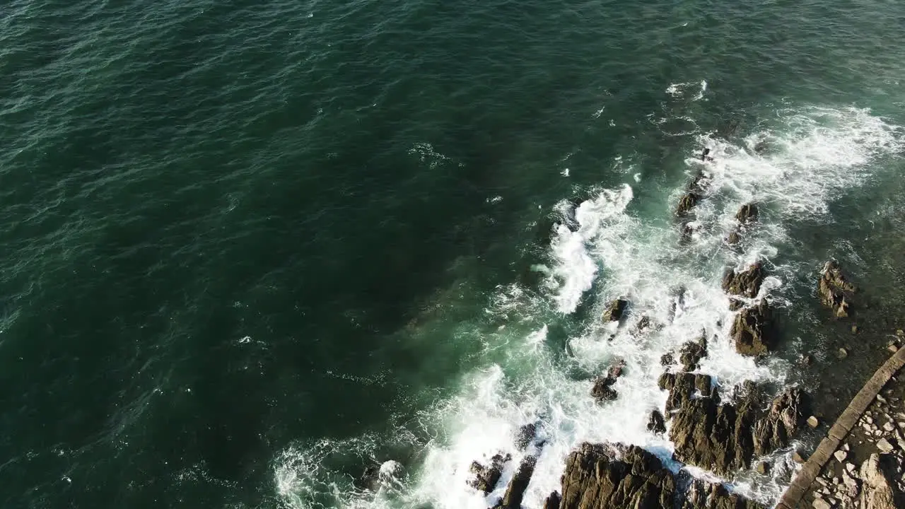 sea waves hitting a rock formation on the shore of the coast