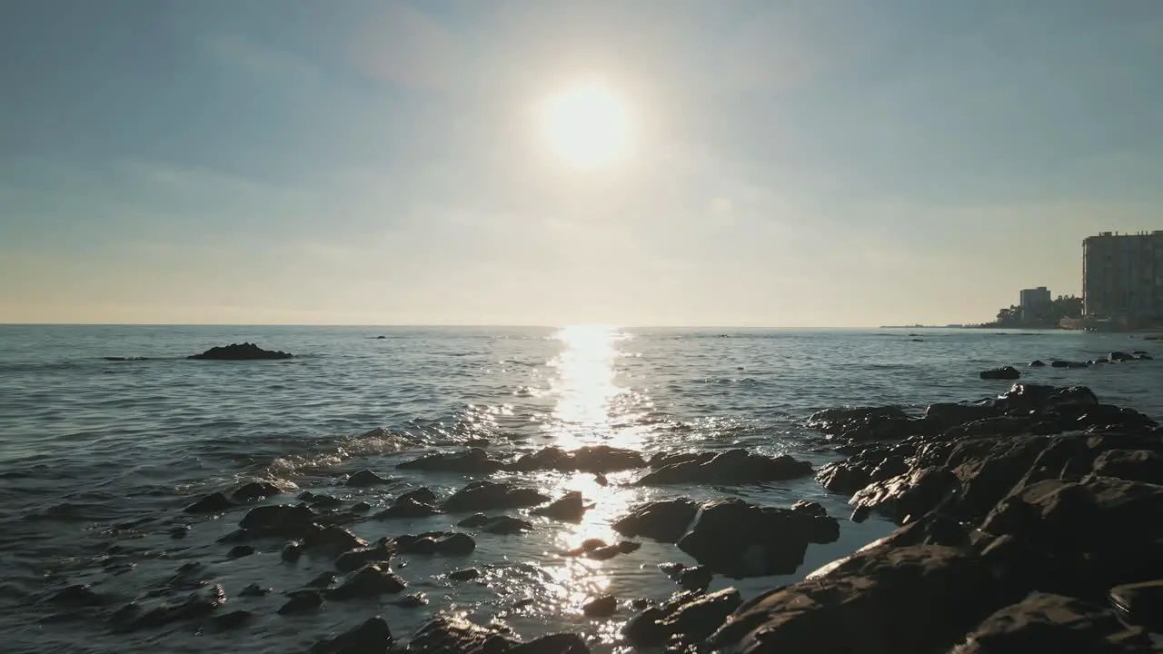 Aerial view of sunny day moving over the rocky beach