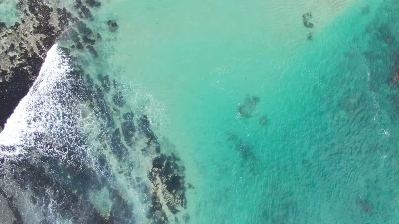 Visible sandy bottom of ocean through clear blue