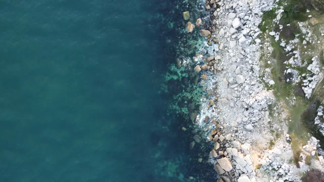 4K Aerial cinematic landscape shot of the coast on the island of Portland during sunset flying towards the beach of Church Ope