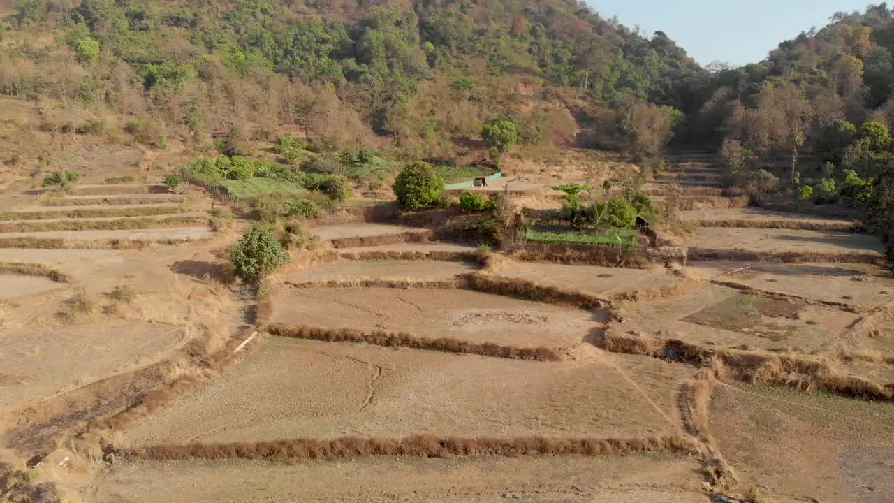 Drone shot over rural dry Indian hillside step farm